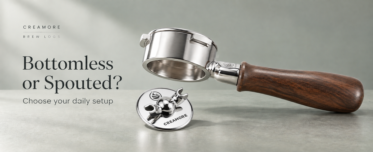 Side view of a Creamore walnut-handled 54mm portafilter with its removable double-spout base on a sage-gray background, titled Bottomless or Spouted?